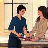 Two people discussing fashion over a table, representing a consulting session.